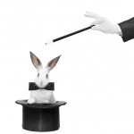 A rabbit in a hat and hand holding a magic wand